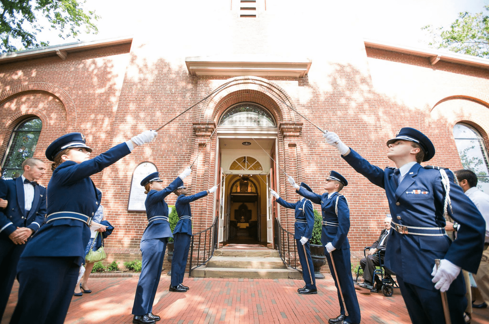 honor guard members hold sabers at entrance of chapel